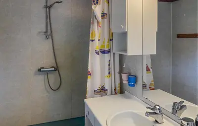 a bathroom with a sink and a shower curtain at Lovely Home In Fiksdalen in Fiksdal
