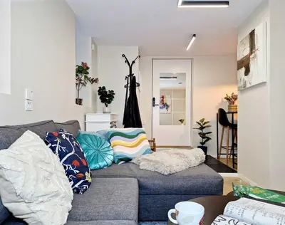 a living room with a gray couch with colorful pillows at Renovated retreat in beautiful area near Bryggen in Bergen