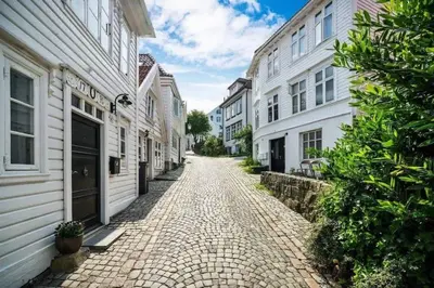 a cobblestone street in a city with white buildings at Renovated retreat in beautiful area near Bryggen in Bergen