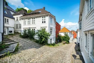 a cobblestone street in a town with white houses at Renovated retreat in beautiful area near Bryggen in Bergen
