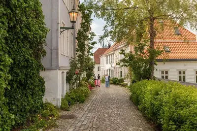 a cobblestone street with people walking down it at Cozy loft with king bed in the middle of town in Bergen