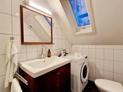 a bathroom with a sink and a washing machine at King bed Great location Top floor in Bergen