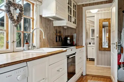 a kitchen with white cabinets and a sink at Charming Cabin By Nesfjellet Ski Resort in Nesbyen
