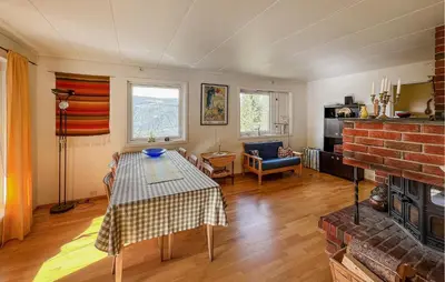 a living room with a table and a fireplace at 3 Bedroom Stunning Home In Sør-Fron in Sør-Fron