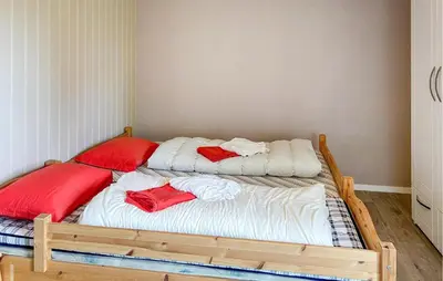 a bedroom with two beds with red pillows on them at 3 Bedroom Stunning Home In Sør-Fron in Sør-Fron