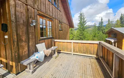 a wooden deck with a bench on the side of a cabin at Awesome Home In Eggedal With Sauna in Eggedal