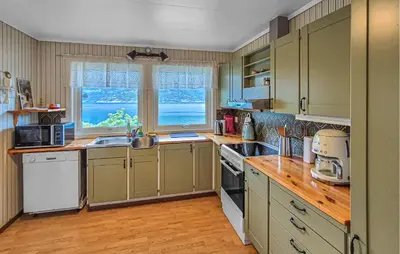a kitchen with green cabinets and a large window at Awesome Home In Eidfjord With House Sea View in Eidfjord