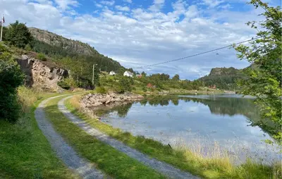 a dirt road next to a river with a mountain at Stunning Home In Korssund With Wifi in Korssund