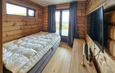 a bedroom with a large bed in a log cabin at Nice Home In Gol With Sauna in Gol