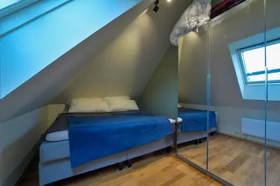 a small room with a bed under the stairs at Penthouse in Bergen