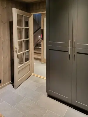 a kitchen with gray cabinets and an open door at Modern Cabin In Norefjell With Sauna in Noresund