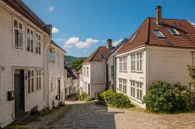 a cobblestone street in a town with white houses at Modern Apartment in the Heart of Bergen in Bergen