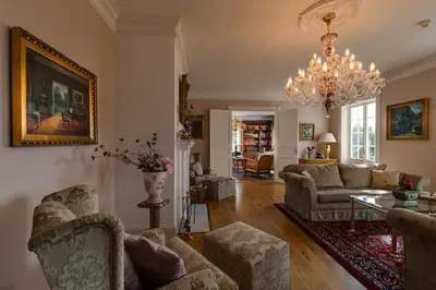 a living room with couches and a chandelier at Villa Grøndalen Gård in Trysil
