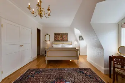a bedroom with a bed and a chandelier at Villa Grøndalen Gård in Trysil