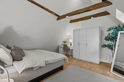 a white bedroom with a bed and a mirror at Large Historic Apartment in the best part of Bergen in Bergen