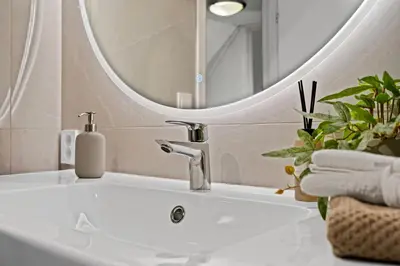 a bathroom with a sink and a mirror at Large Historic Apartment in the best part of Bergen in Bergen