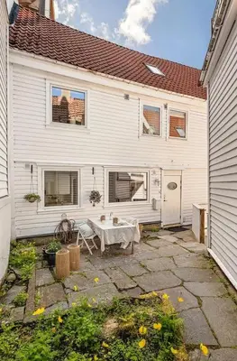 a white house with a table in front of it at Large Historic Apartment in the best part of Bergen in Bergen
