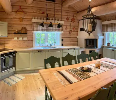 a kitchen with a table and a dining room at Traditional Log Cabin By Lake Mykletjønn in Austbygdi