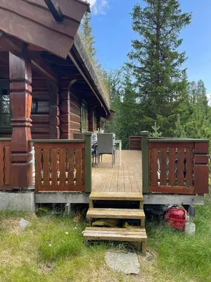 a porch of a log cabin with a wooden deck at Traditional Log Cabin By Lake Mykletjønn in Austbygdi
