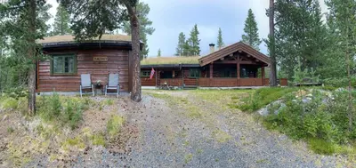 a log cabin with two chairs in front of it at Traditional Log Cabin By Lake Mykletjønn in Austbygdi