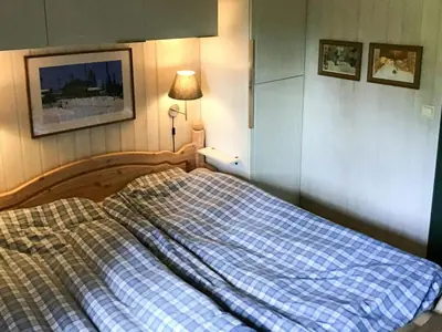 a bed in a bedroom with a blue plaid at Spacious Family Cabin With Views In Hafjell in Øyer