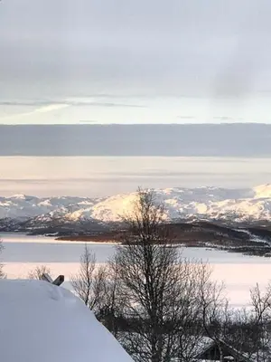 a person riding a snowboard on top of a snow covered slope at Authentic Cabin Overlooking Lake Møsvann in Rjukan
