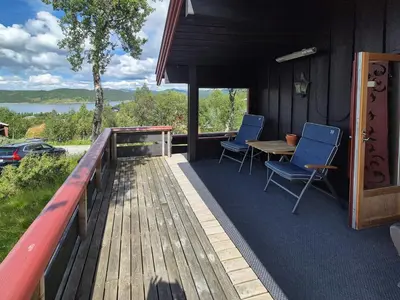 a deck with chairs and a table on a house at Authentic Cabin Overlooking Lake Møsvann in Rjukan