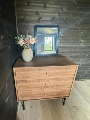 a dresser with a mirror and a vase with flowers on it at Mountain Cabin With Beautiful Lake View in Hemsedal