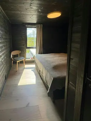 a bedroom with a bed and a table and a window at Mountain Cabin With Beautiful Lake View in Hemsedal