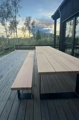 a wooden picnic table sitting on a wooden deck at Mountain Cabin With Beautiful Lake View in Hemsedal
