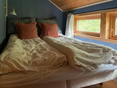 a bed in a room with a window at Traditional Log Cabin By Lake Seljord in Seljord