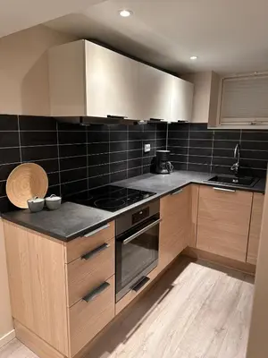 a kitchen with wooden cabinets and a stove top oven at Free parking grand floor Apartment in Ålesund in Ålesund