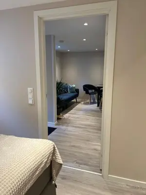 a bedroom with a door leading to a living room at Free parking grand floor Apartment in Ålesund in Ålesund