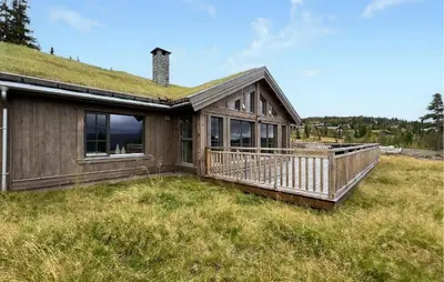 a house with a grass roof with a deck at Lovely Home In Gålå With Sauna in Gålå