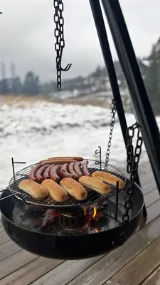 a grill with sausages and hot dogs on it at Modern and cozy mountain cabin - panoramic view! in Torvetjørn