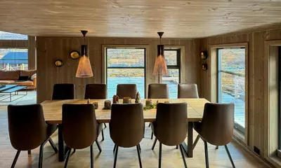 a dining room with a wooden table and chairs at Modern cottage in the heart of the Sunnmøre Alps in Sykkylven