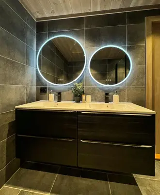 a bathroom with two sinks and two mirrors at Modern cottage in the heart of the Sunnmøre Alps in Sykkylven