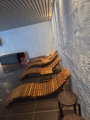 a group of wooden benches sitting next to a wall at 