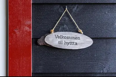 a sign hanging on a wall with the words voliemen til lyrica at Mountain Dream in Vossevangen