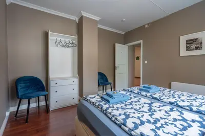 a bedroom with a bed and two blue chairs at Big, Bright & Beautiful - with 6 Large Bedrooms in Bergen