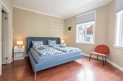 a bedroom with a blue bed and a red chair at Big, Bright & Beautiful - with 6 Large Bedrooms in Bergen