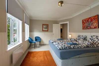 a bedroom with a bed and two chairs and a window at Big, Bright & Beautiful - with 6 Large Bedrooms in Bergen