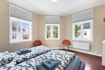 a bedroom with a bed and two chairs and windows at Big, Bright & Beautiful - with 6 Large Bedrooms in Bergen