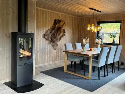 a dining room with a table and chairs and a fireplace at Elegantes, ruhiges Ferienhaus in bester Lage für alle Outdoorfans in Randsverk