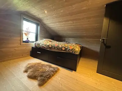 a small bedroom with a bed and a rug at Elegantes, ruhiges Ferienhaus in bester Lage für alle Outdoorfans in Randsverk