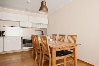 a kitchen with a wooden table and chairs at Leiligheter i sentralt Bergenshus in Bergen