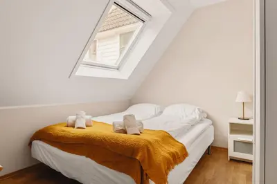 a bedroom with a bed with two towels on it at Leiligheter i sentralt Bergenshus in Bergen