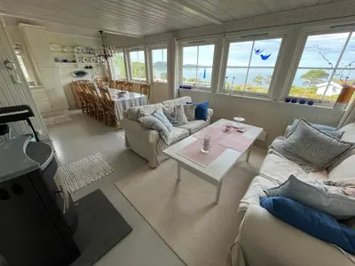 a living room with two couches and a table at Stor hytte med praktfull havutsikt in Lysøysund