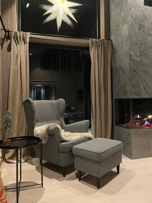 a living room with a chair and a fire place at Fjellro Budor - ski in ski out in Løten