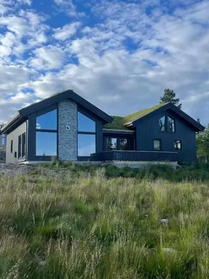 a house with a grass roof on top of a field at Fjellro Budor - ski in ski out in Løten
